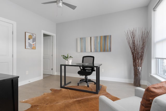 office area with a ceiling fan, baseboards, and wood finished floors