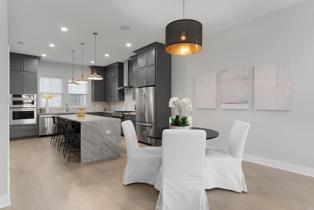 dining area with recessed lighting, light wood-style flooring, and baseboards