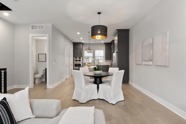 dining room featuring recessed lighting, baseboards, visible vents, and light wood-type flooring