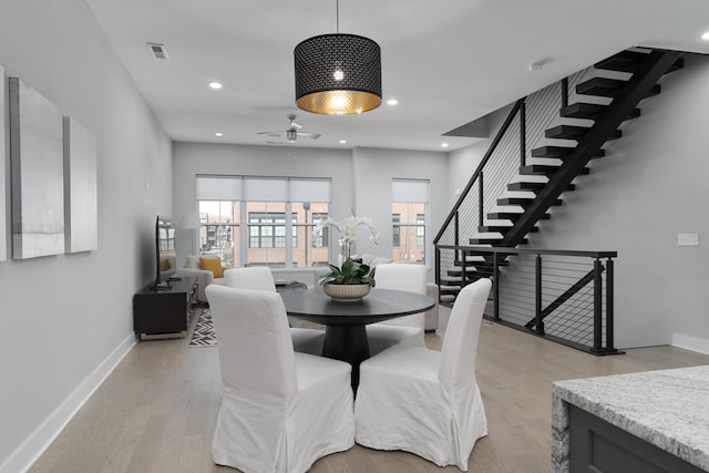 dining room with light wood finished floors, visible vents, baseboards, stairway, and recessed lighting