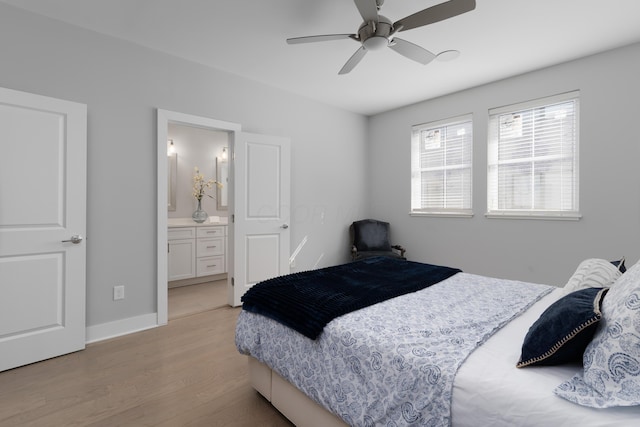 bedroom featuring light wood-type flooring, baseboards, ensuite bath, and a ceiling fan