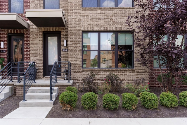 view of exterior entry featuring brick siding