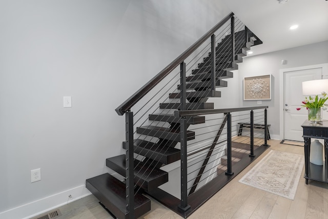 staircase featuring recessed lighting, baseboards, and wood finished floors