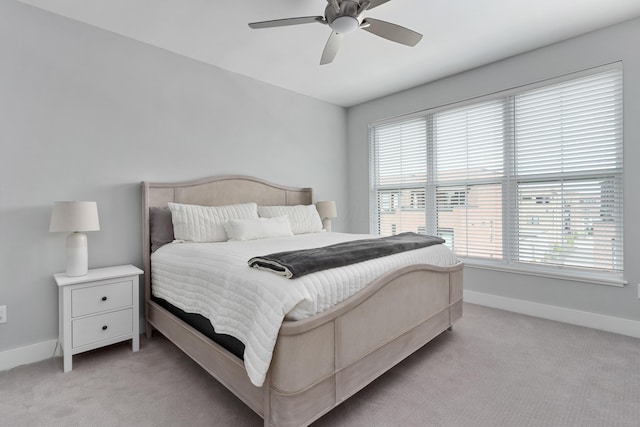 bedroom with light colored carpet, baseboards, and multiple windows