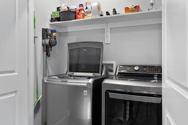 clothes washing area with independent washer and dryer and laundry area