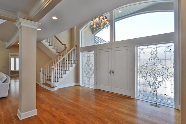 entrance foyer with visible vents, stairway, recessed lighting, wood finished floors, and ornate columns