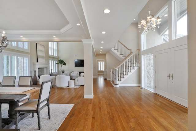 foyer with a notable chandelier, light wood-style flooring, stairway, and a high ceiling