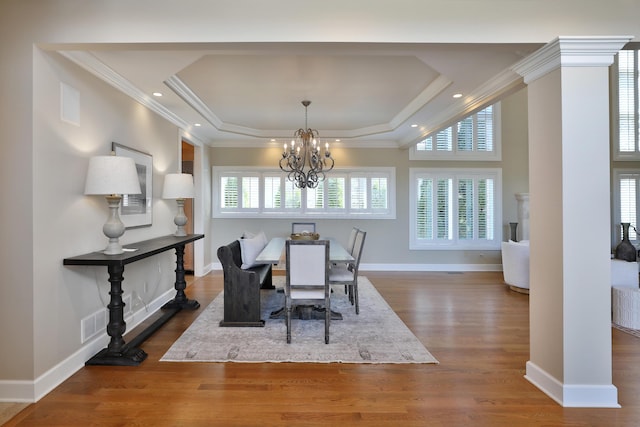 dining room featuring a tray ceiling, wood finished floors, and ornamental molding