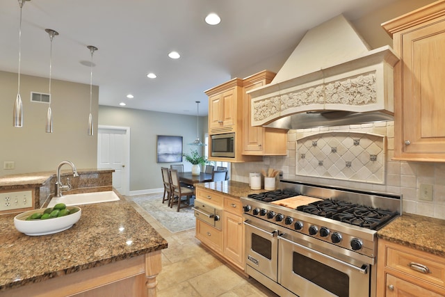 kitchen featuring visible vents, a sink, backsplash, stainless steel appliances, and custom exhaust hood