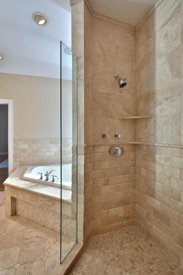 bathroom with tiled shower and a garden tub