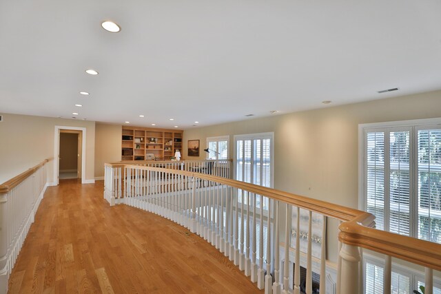 corridor featuring light wood finished floors, visible vents, and recessed lighting