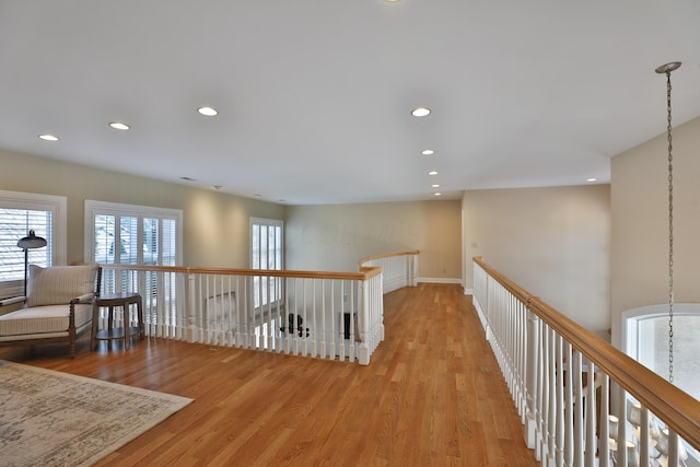 hall featuring an upstairs landing, recessed lighting, and light wood finished floors