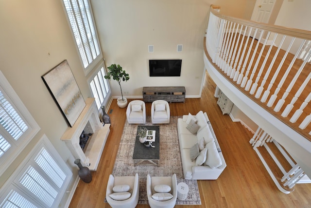 living room with baseboards, a towering ceiling, and wood finished floors