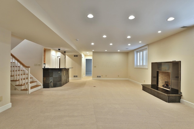 basement with baseboards, a tiled fireplace, stairway, light carpet, and recessed lighting