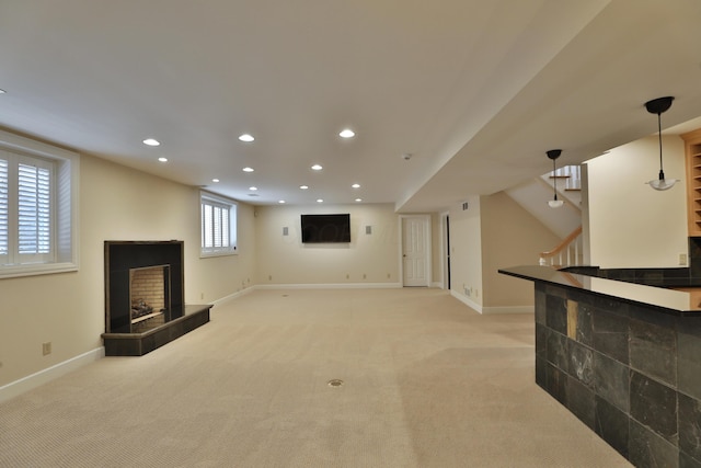 interior space featuring baseboards, light colored carpet, stairs, recessed lighting, and a fireplace