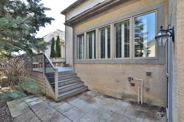 view of side of property with a patio area and stucco siding