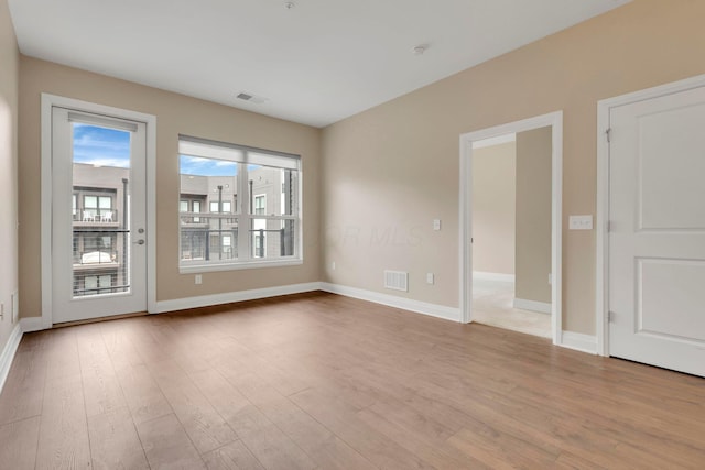 unfurnished room with visible vents, baseboards, and wood finished floors