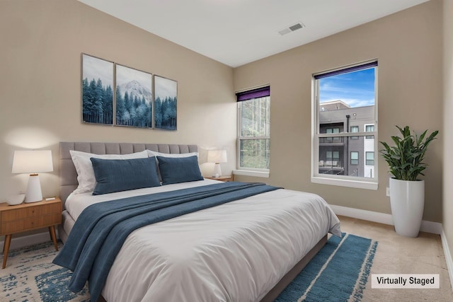 carpeted bedroom featuring visible vents and baseboards