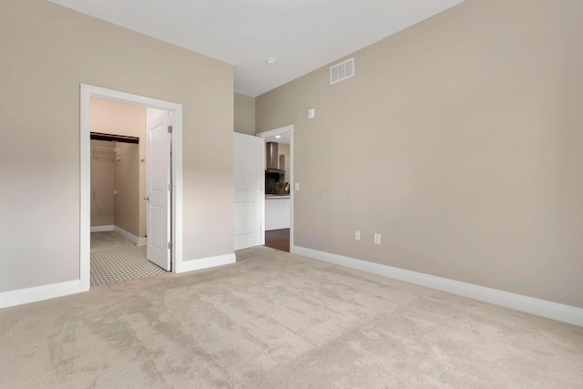 unfurnished bedroom with light carpet, baseboards, and visible vents