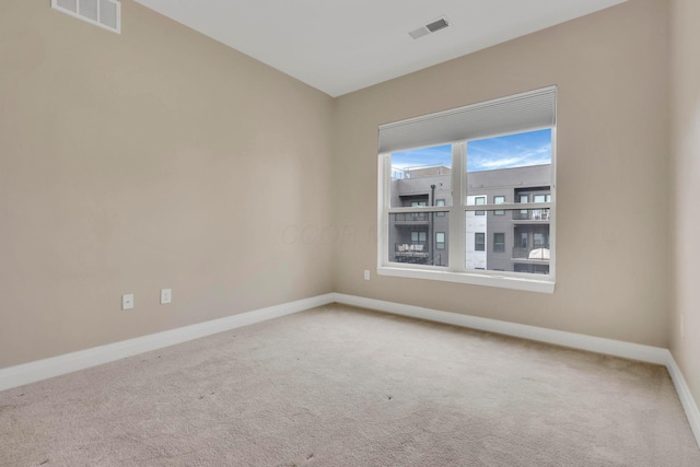 carpeted empty room with baseboards and visible vents