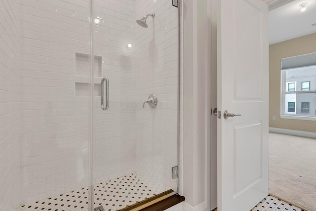 full bathroom with a shower stall and baseboards