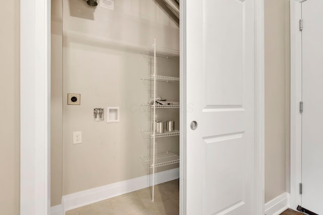 laundry room with hookup for a washing machine, hookup for an electric dryer, laundry area, baseboards, and tile patterned floors