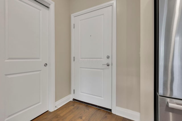 doorway to outside with dark wood-style floors and baseboards