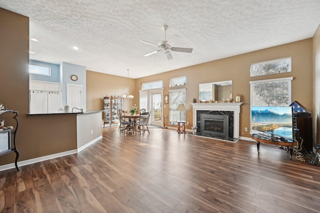 living room with dark wood-style floors, a high end fireplace, a textured ceiling, and baseboards