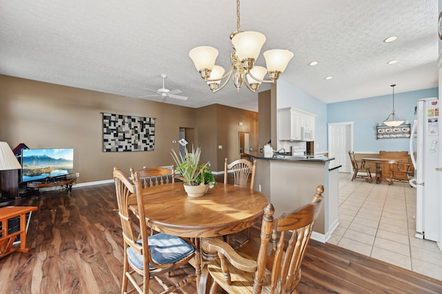 dining area featuring recessed lighting, a textured ceiling, wood finished floors, baseboards, and ceiling fan with notable chandelier