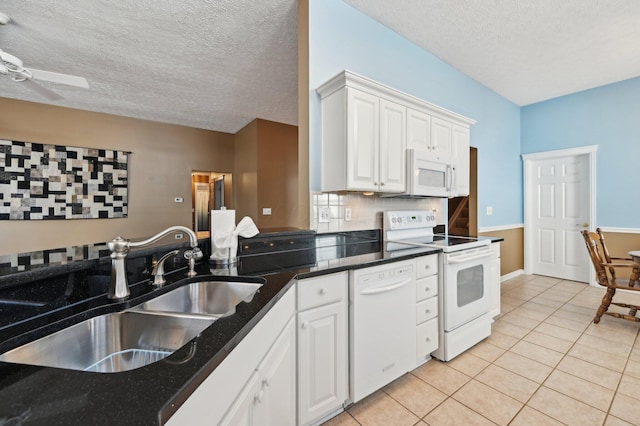 kitchen featuring light tile patterned floors, decorative backsplash, white cabinetry, a sink, and white appliances