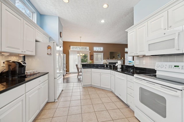 kitchen featuring white appliances, light tile patterned floors, decorative backsplash, a peninsula, and white cabinetry