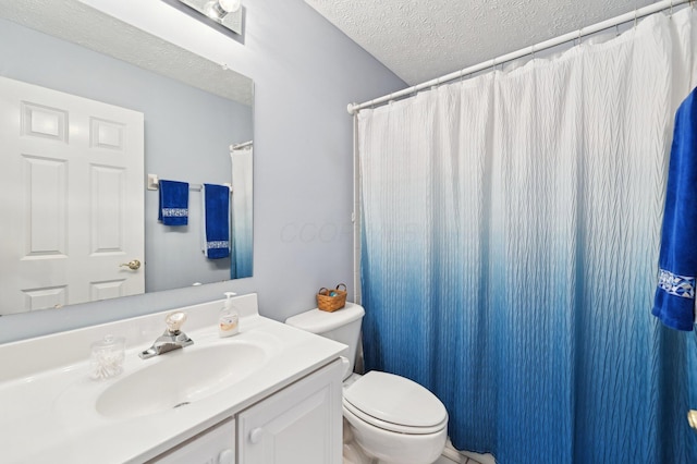 bathroom featuring toilet, a textured ceiling, and vanity