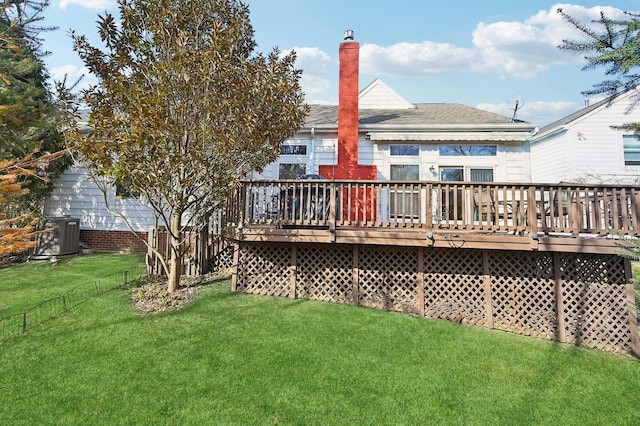 back of house featuring central AC unit, a lawn, a chimney, and a wooden deck