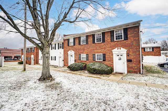 colonial house featuring brick siding