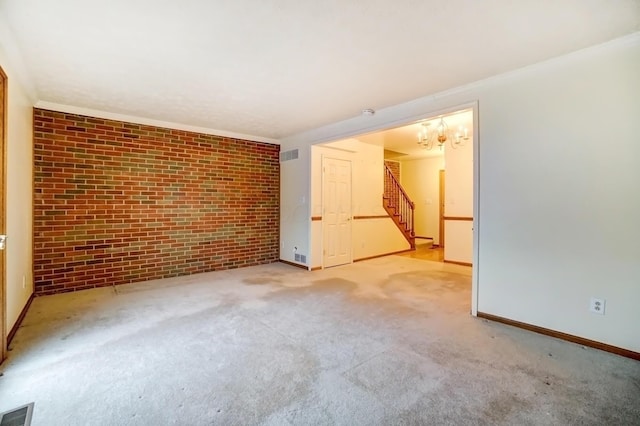 unfurnished room with carpet floors, brick wall, stairs, and visible vents