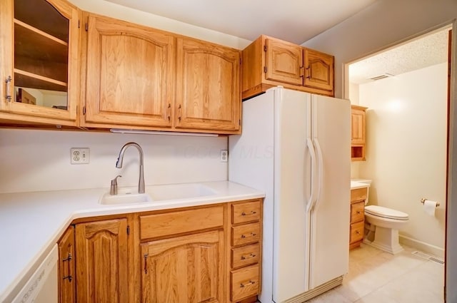 kitchen featuring light countertops, white appliances, a sink, and visible vents