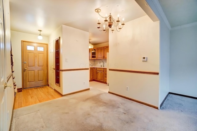 entrance foyer featuring light colored carpet, a notable chandelier, and baseboards