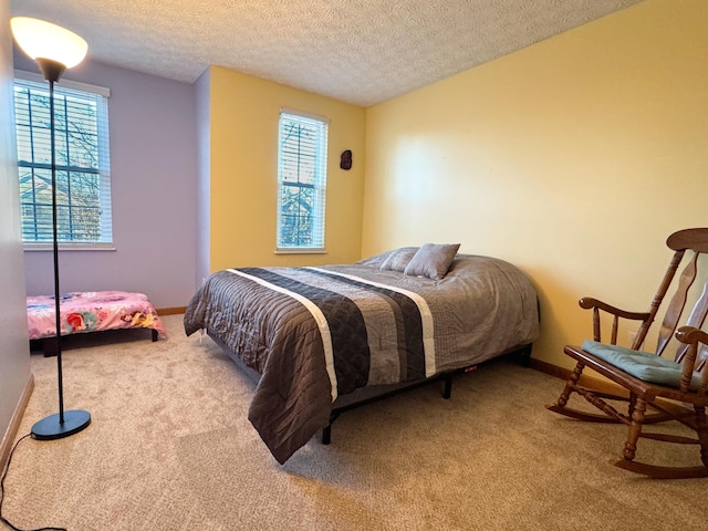 carpeted bedroom with a textured ceiling and baseboards