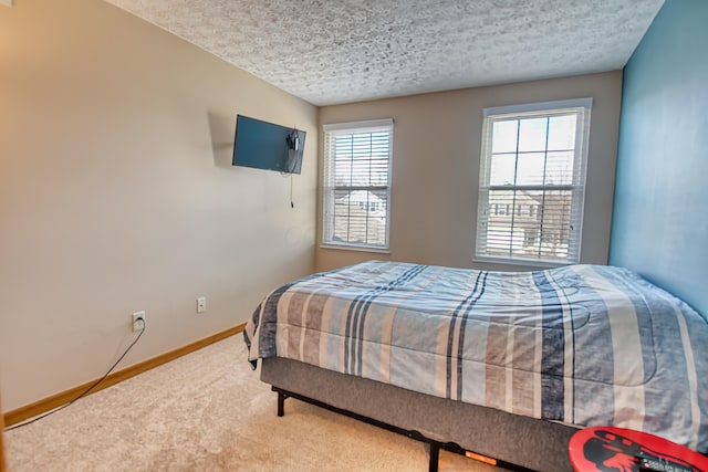 carpeted bedroom featuring a textured ceiling and baseboards