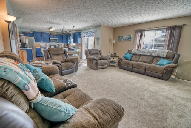 living area featuring light carpet, an inviting chandelier, and a textured ceiling