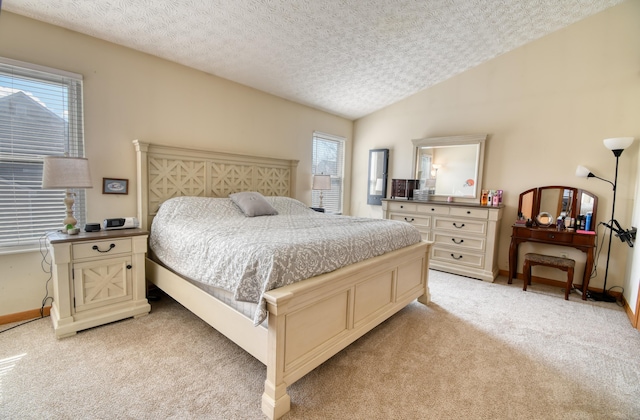 bedroom featuring vaulted ceiling, a textured ceiling, baseboards, and light colored carpet