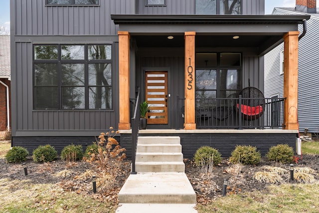 entrance to property with board and batten siding and covered porch