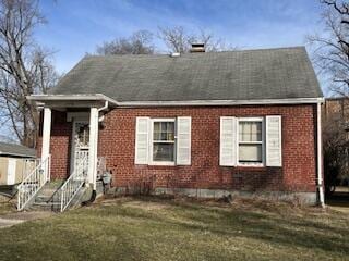 view of front of home featuring brick siding and a front lawn