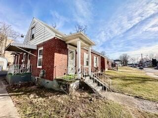 view of front of property featuring a front lawn and brick siding