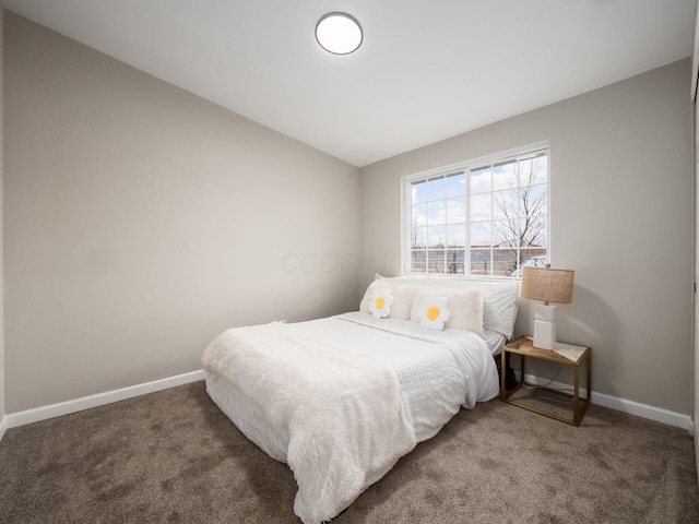 carpeted bedroom featuring lofted ceiling and baseboards