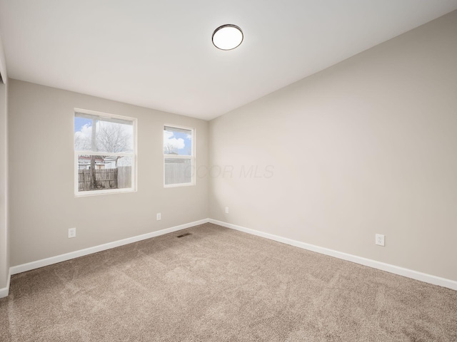 unfurnished room featuring carpet and baseboards