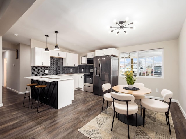 kitchen featuring tasteful backsplash, lofted ceiling, electric range oven, stainless steel fridge, and a peninsula