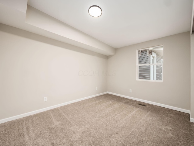 unfurnished room featuring carpet floors, visible vents, and baseboards