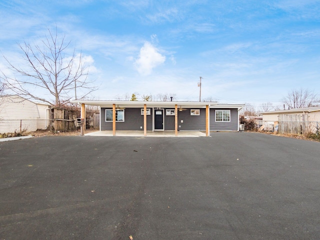 view of front facade with driveway, fence, and a carport