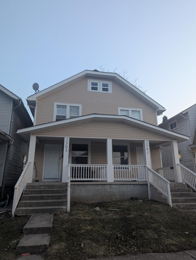 american foursquare style home with covered porch